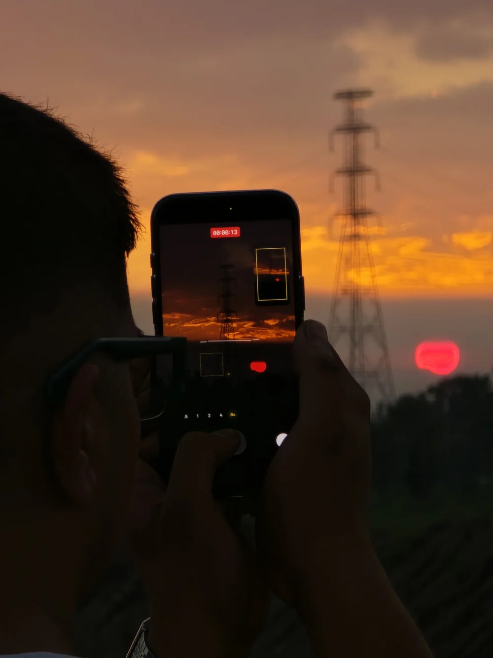The founder of Reminedial High capturing the sunset on a phone